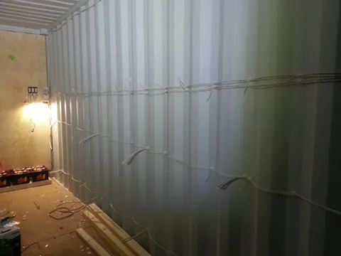The first cable runs fixed along the corrugated wall.