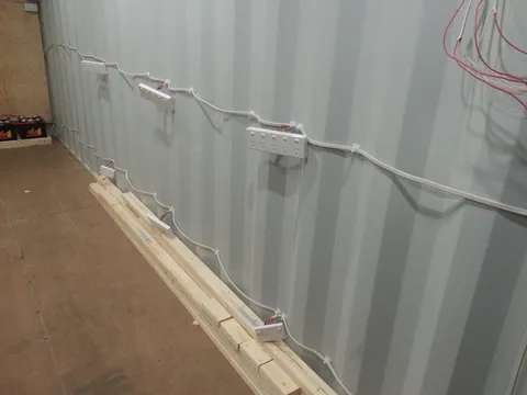 The row of outlet boxes along the container wall.