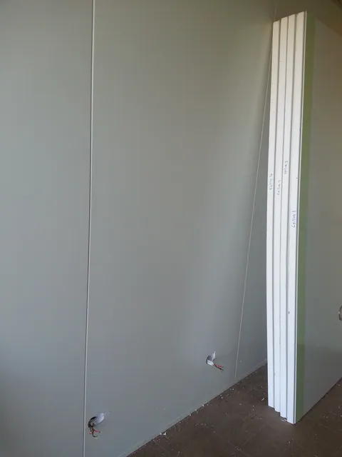 A wall panel fitted along one side of the container.