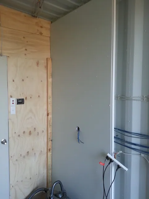 The partly lined wall meeting the rear partition.