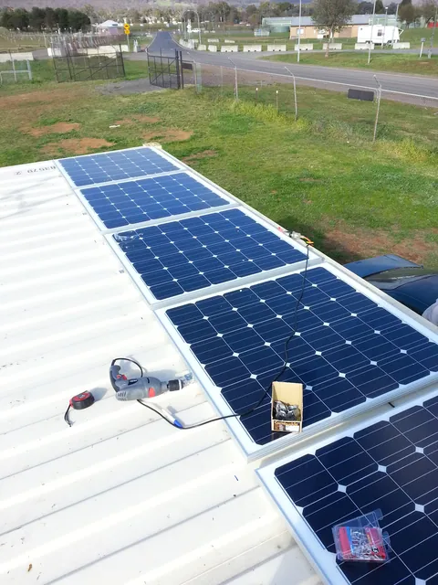 Solar panels being installed along the container roof.