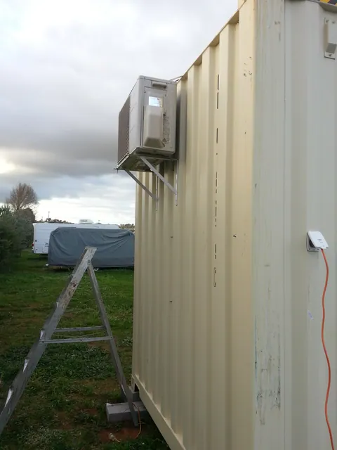 The mounted air-conditioning unit viewed along the container side.