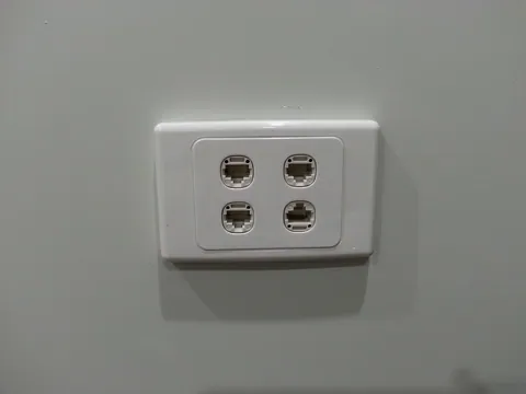 A four-port data outlet installed in the finished wall.