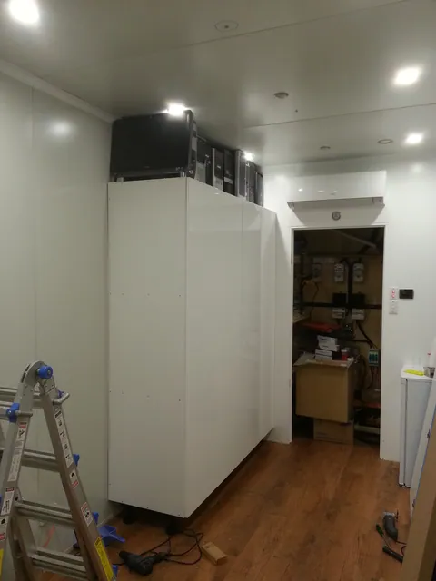 The storage wall with computers above the cupboards.