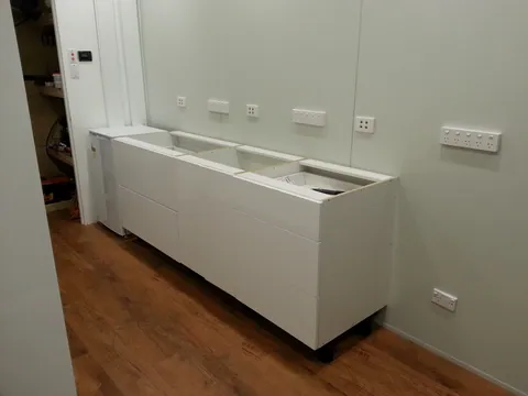 Base cabinet frames positioned below the wall outlets.