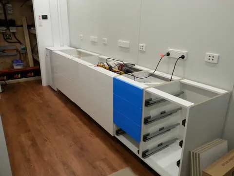 Drawers and cabinet fronts being fitted below the future workbench.