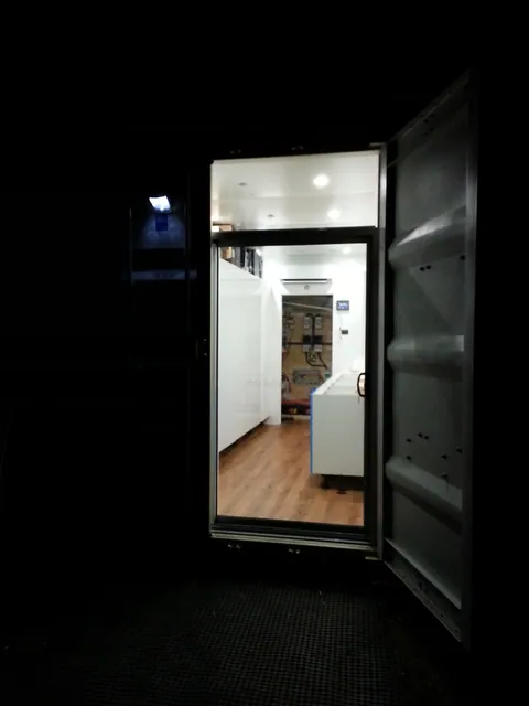 The lit workshop inside the open container at night.