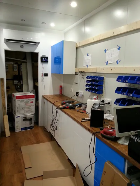 The first upper cabinets installed above the repair bench.