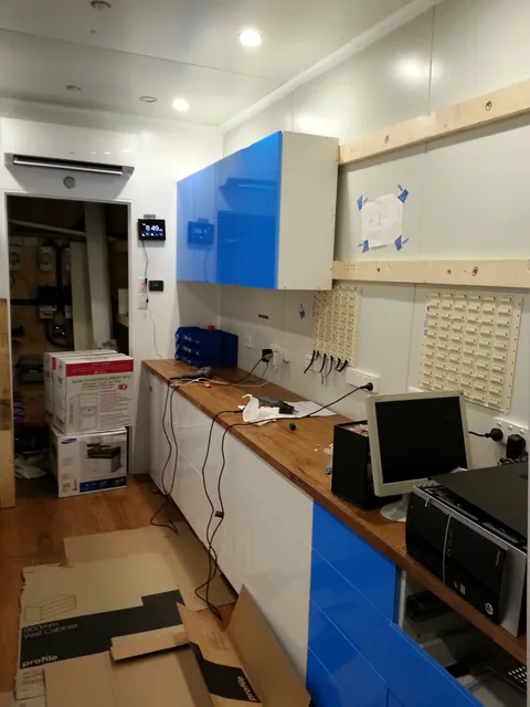 The upper cabinet installation advancing over the bench.