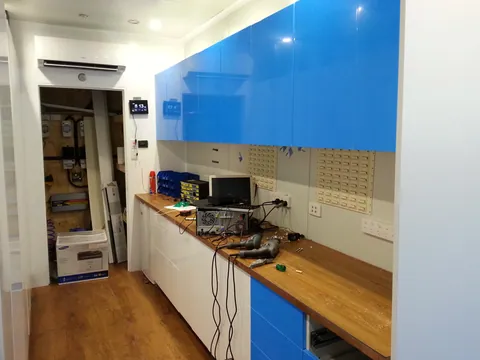 The upper cupboard fronts fitted along the repair bench.