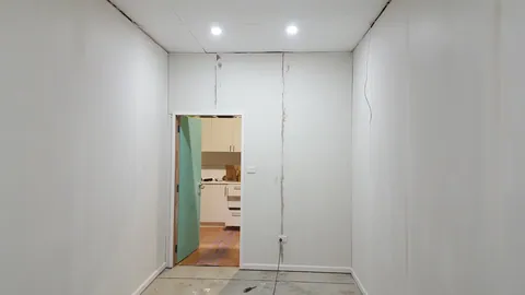 The room is masked and prepared for finishing.