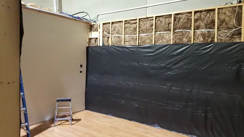 Black membrane starts covering the insulated wall.