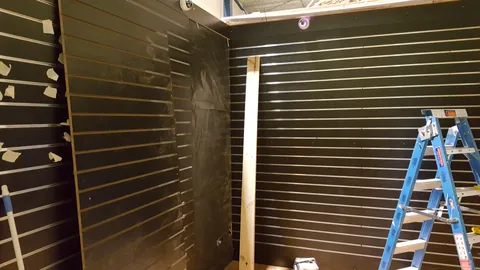 The first slatwall panels start turning the frame into a display wall.