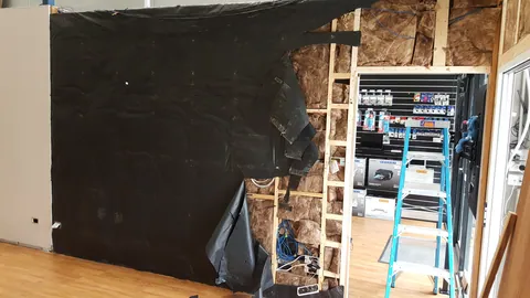 Black membrane begins covering the new wall.