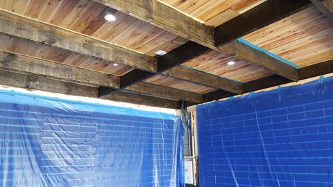 Painting progresses along the overhead beams.