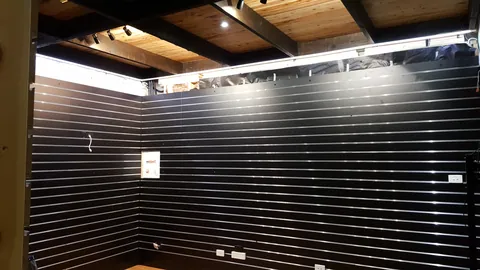 Dark-painted beams frame the new ceiling and display walls.