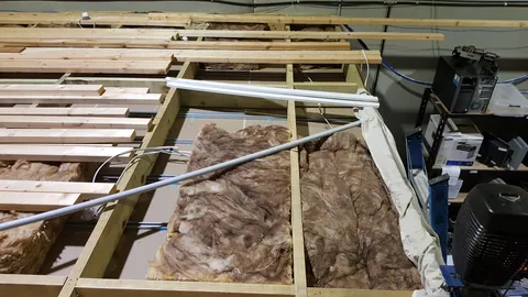 An above-ceiling view records the insulation before the space is closed up.