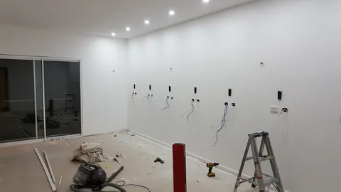 Service cables emerge along the wall where the benches will be fitted.