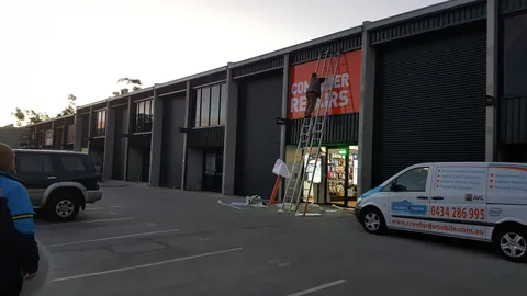 A wider evening view puts the Mitchell shopfront in its row of units.