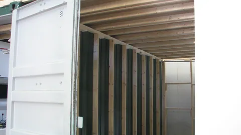 An outside view records the new framing beside the existing container door.