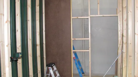 Wall lining starts to cover the exposed framing.