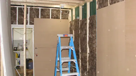 Insulation and new lining meet partway along the wall.