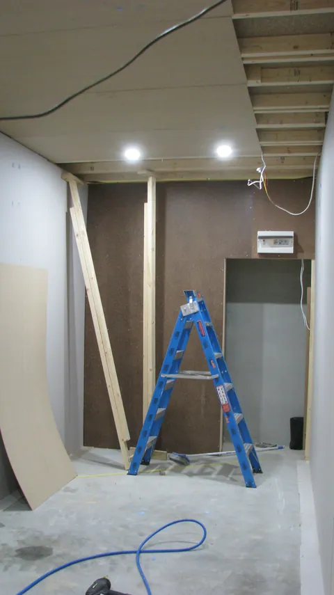 Lights are on as the last ceiling edges are finished.