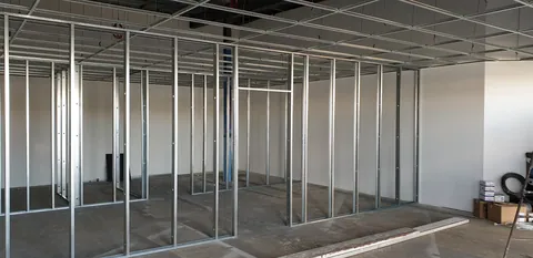 Metal wall framing divides the former open space into rooms.