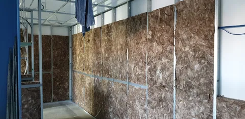 Insulation being fitted between the wall studs.