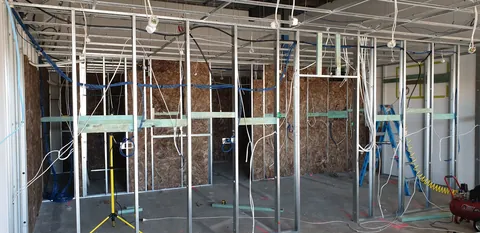 The insulation work progressing across the framed rooms.