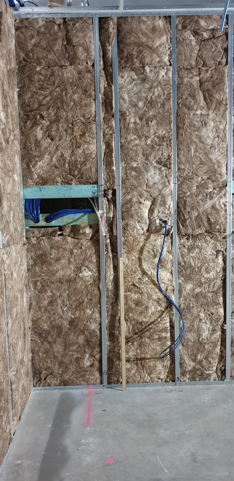 A closer view of insulation within the vertical wall framing.