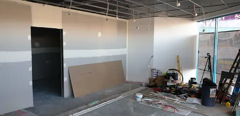 The retail area with newly lined walls and the ceiling grid above.