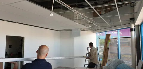 Ceiling panels being installed above the retail area.