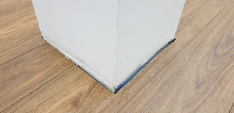Flooring cut around a corner and the existing structure.