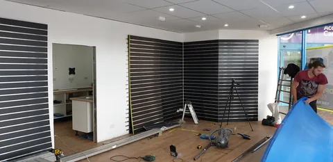 The first retail display-wall panels being fitted.