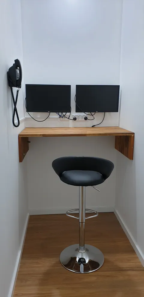 A smaller work area fitted with two screens and a stool.