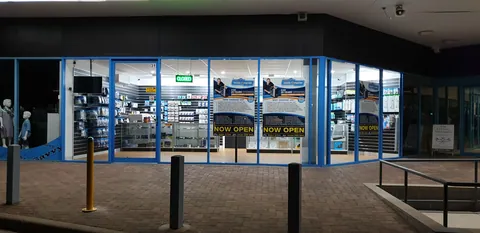 Now Open signs displayed across the illuminated shopfront.