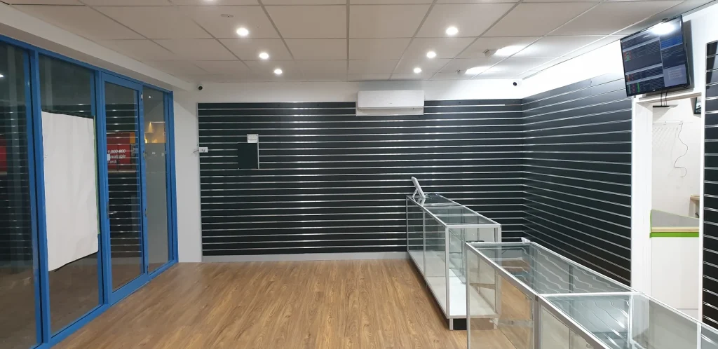 Completed showroom display walls and empty glass counters beneath the finished ceiling