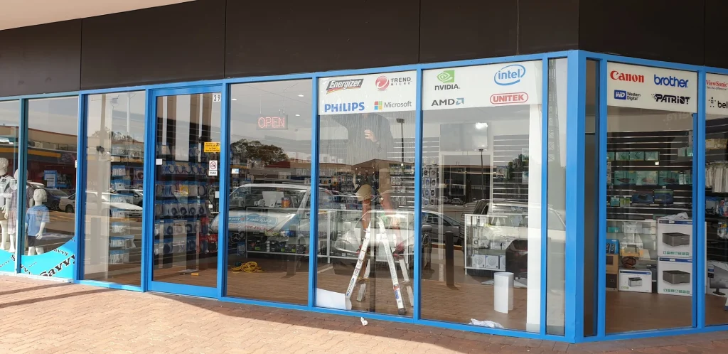 Blue Crawfords shopfront with brand signs, stocked shelves, glass counters and an illuminated open sign