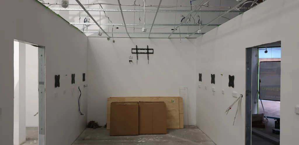 New workshop walls with monitor brackets, electrical outlets and cables before bench installation