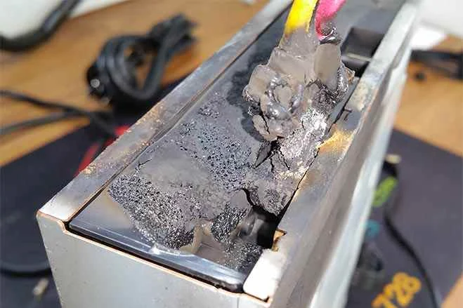 DVD drive with melted and charred plastic around its power connector and wires