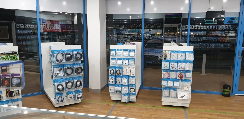 Cable and accessory display stands by the blue front windows inside the Greenway shop